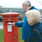 A man and woman posting a letter