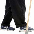 The legs of a person walking with a stick
