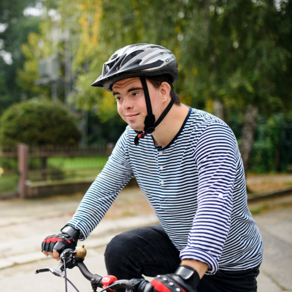 young person riding a bike outside wearing a helmet 