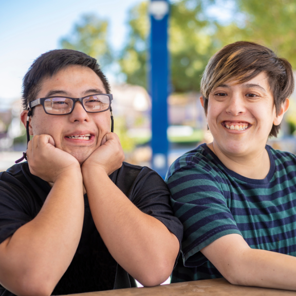 Two young people sitting down and smiling