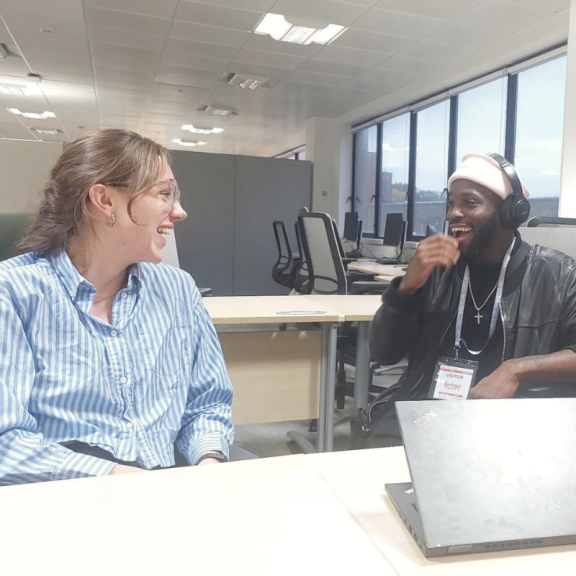 youth council member sitting at a desk smiling with council employee