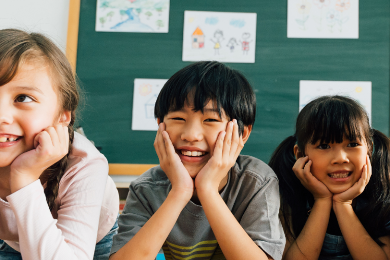 Three students smiling in a classroom