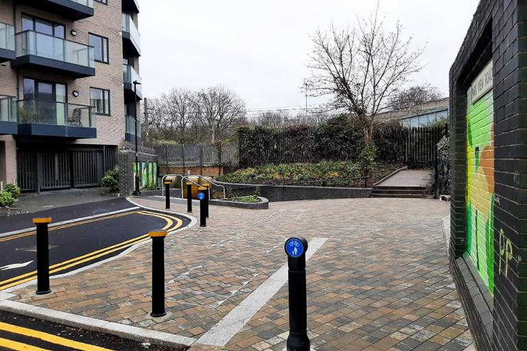 A paved pedestrian walkway with a wall of murals on either side