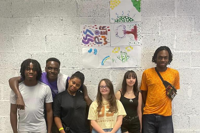 Young people smiling against wall with drawings