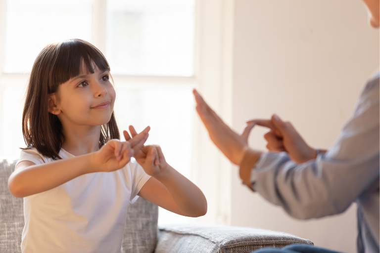young child and an adult communicating in British Sign Language