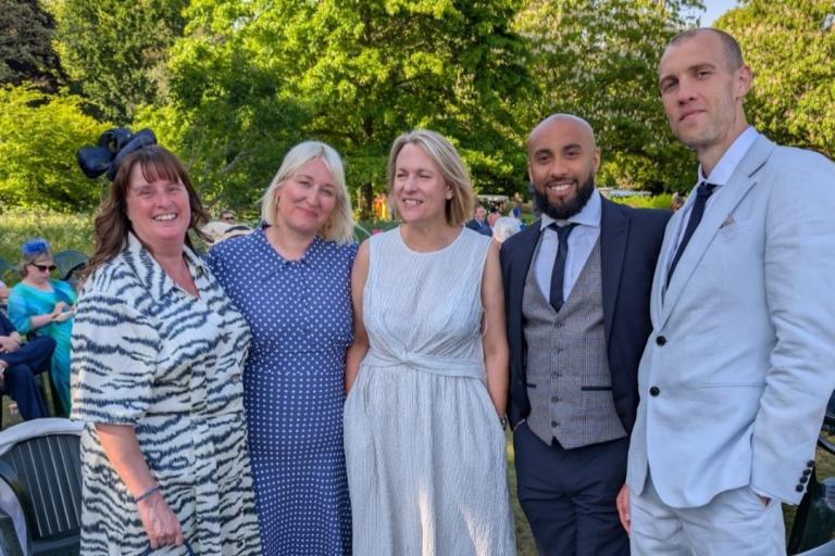 Five colleagues from Children Services smiling outdoors at a garden party