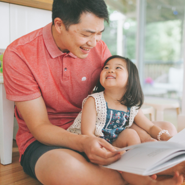 Father and young daughter together reading