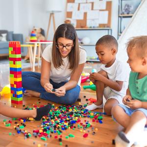 Three children and an adult playing with blocks.