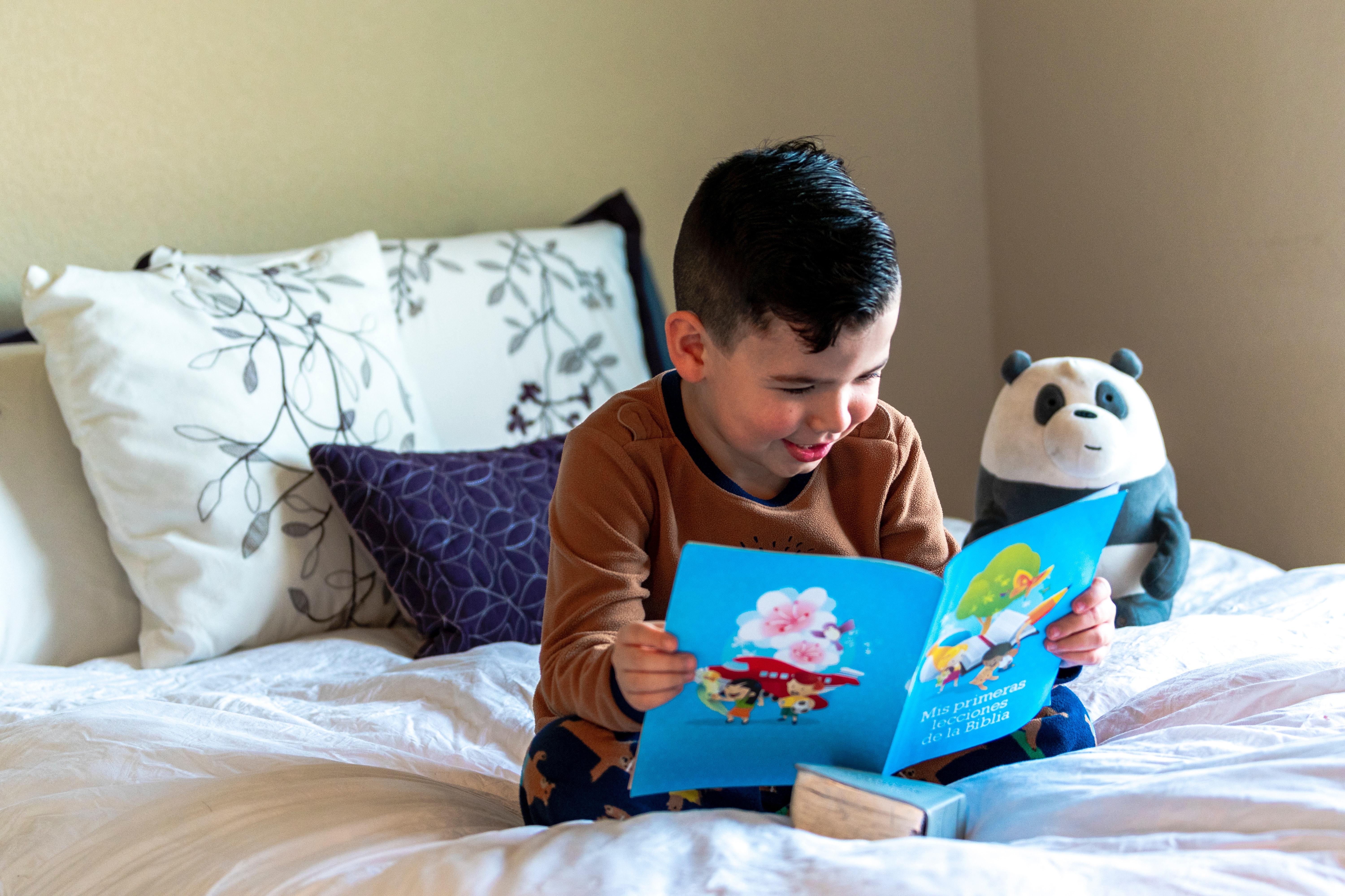 Young boy sitting on his bed