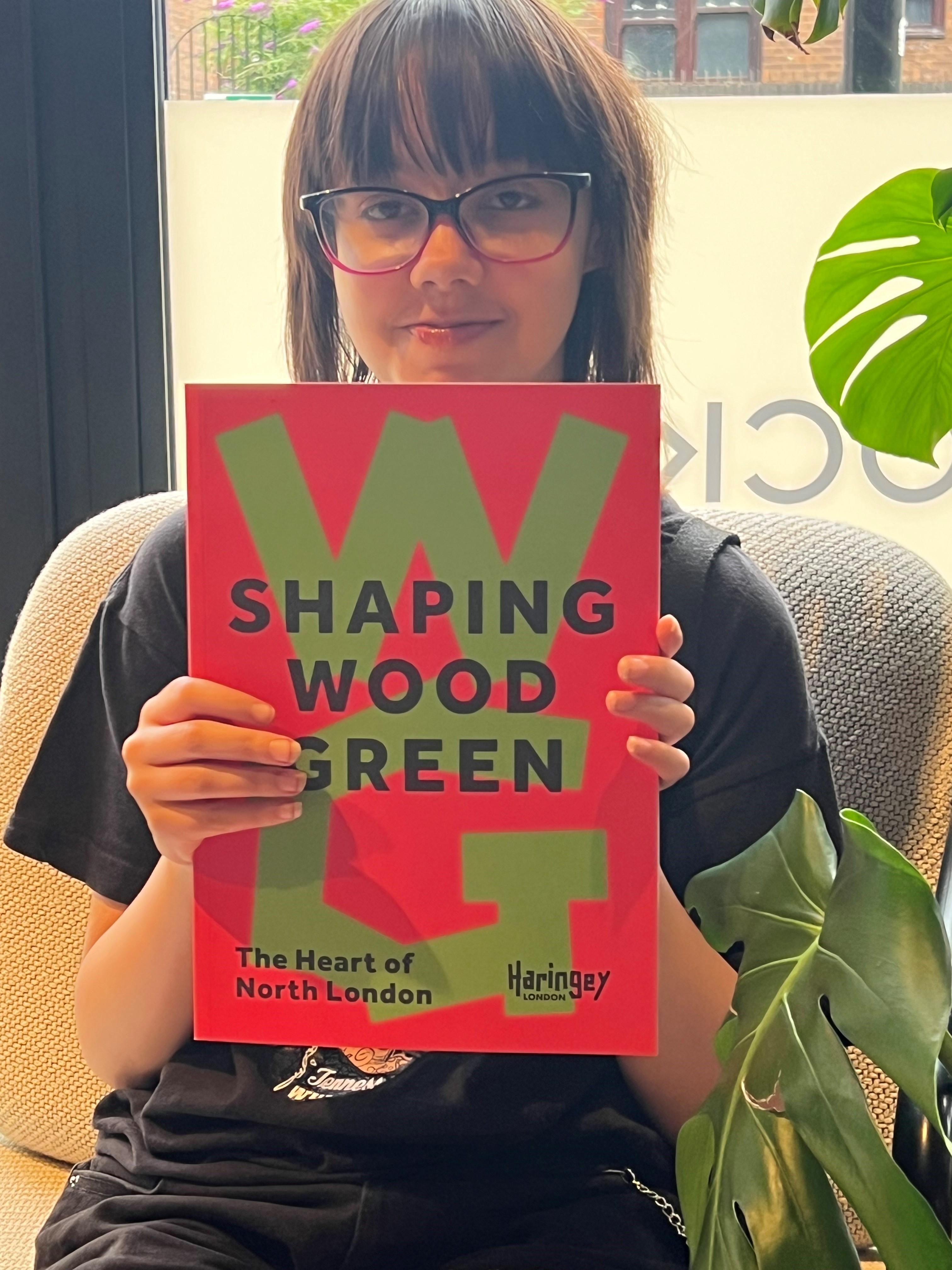 image of young person holding a book with the text, Shaping Wood Green